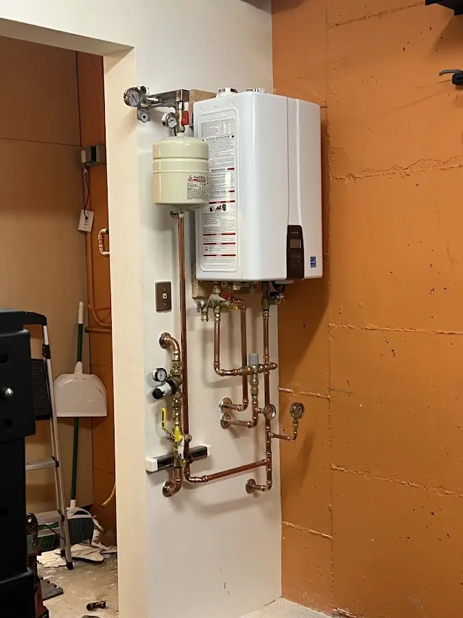 Plumbing technician inspecting water heater connections in Oakmont